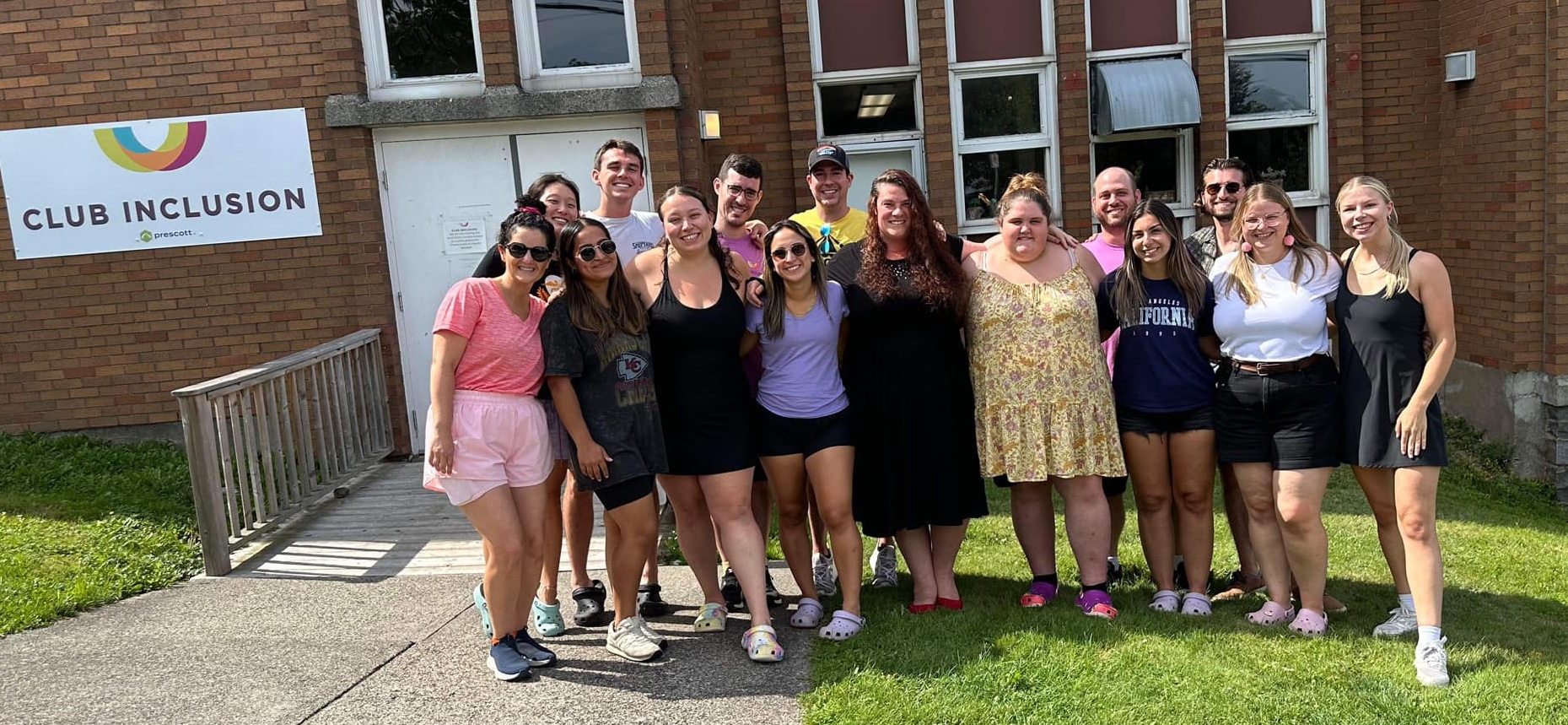 summer camp support team pose together outside of building.